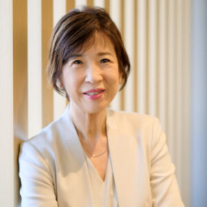 温かな光を背景に、腕組をして微笑む白石社会保険労務士