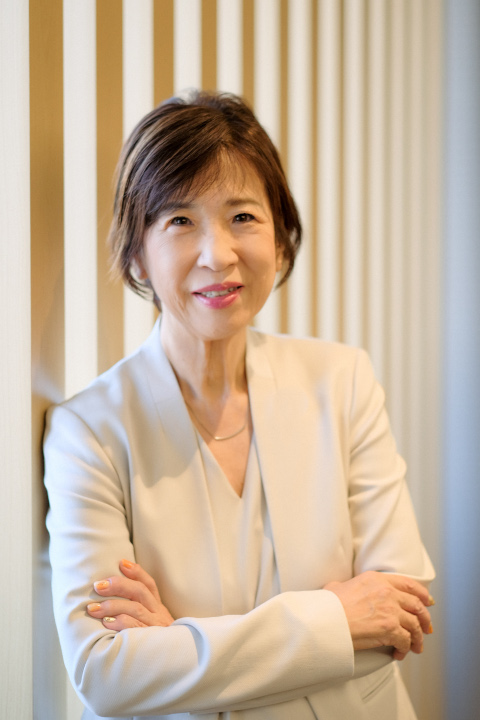 温かな光を背景に、腕組をして微笑む白石社会保険労務士