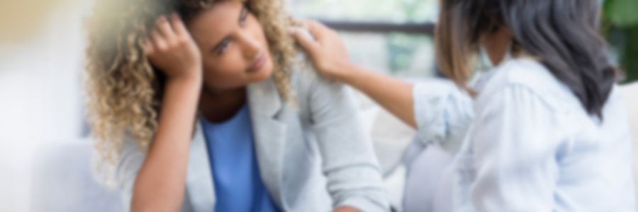 メンタルヘルス研修のイメージ図。頭を抱える女性の肩に同僚が優しく手をかけている。